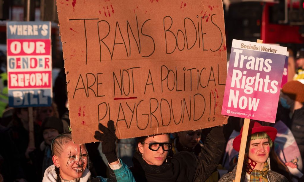 A trans rights supporter holds up a sign reading "Trans bodies are not a political playground" during a protest against the UK Goverment Section 35 stopping Scotland's gender recognition reform bill