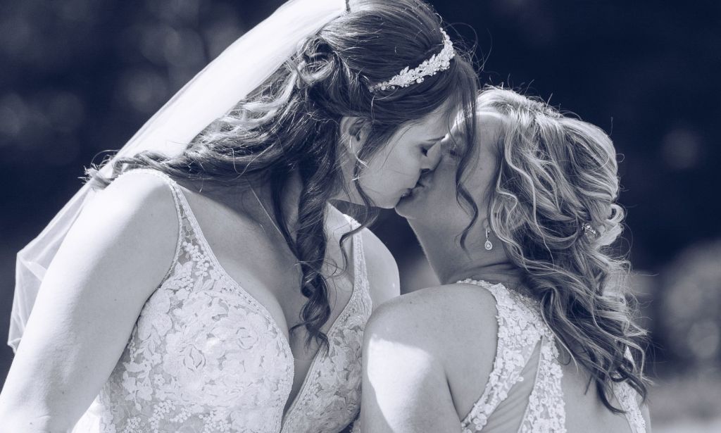 Sophie Rebecca and her partner both wear wedding dresses and kiss as they get married