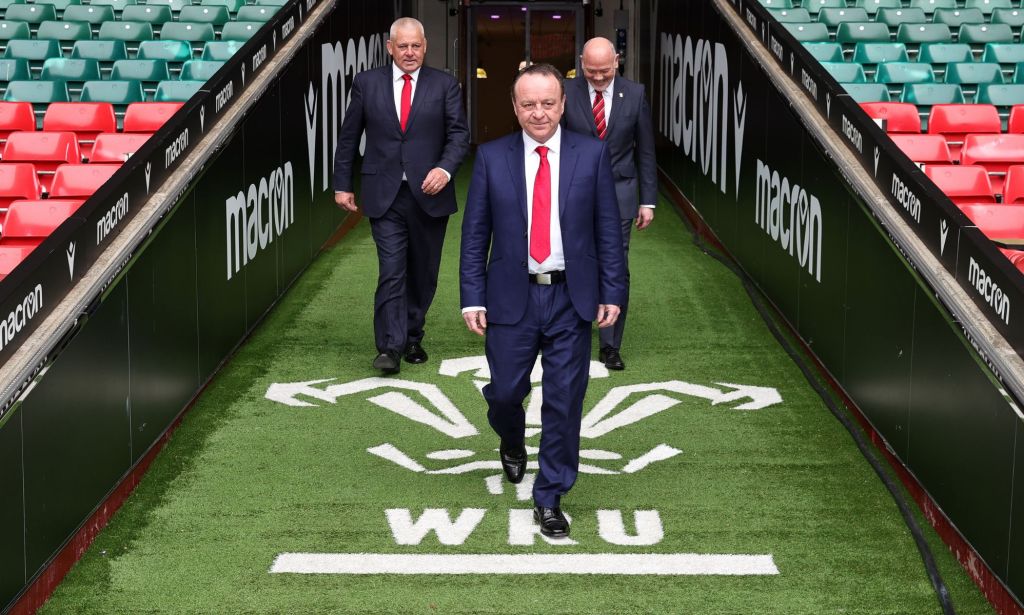 Warren Gatland walks onto the pitch with Steve Phillips and Ieuan Evan with the Welsh Rugby Union logo below their feet