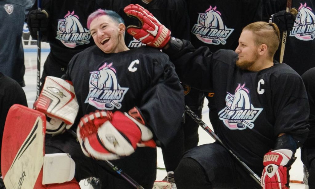 Mason LeFebvre and Danny Maki smile at each other while wearing Team Trans hockey uniforms for a team photo