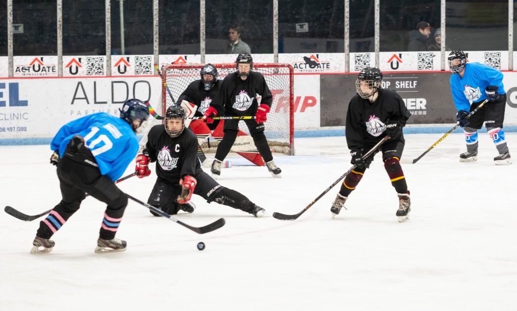 Players for Team Trans play hockey against each other on the ice