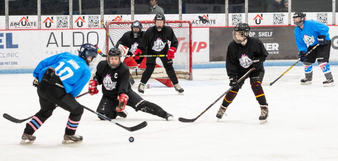 Players for Team Trans play hockey against each other on the ice