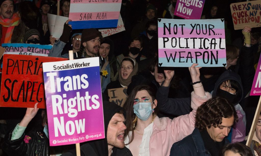 Transgender people and their supporters hold up signs and should as they demonstrate outside Downing Street against the UK government's decision to block the Scottish Gender Recognition Bill