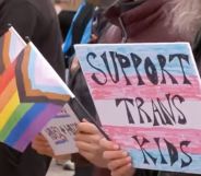 A person holds up a sign reading 'support trans kids' during a protest in Utah