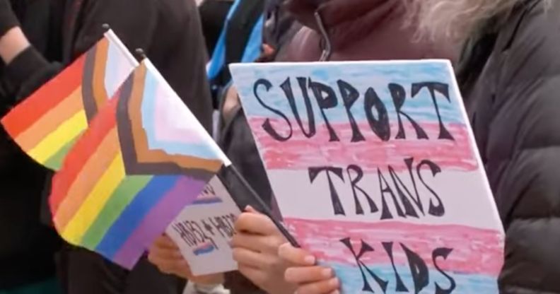 A person holds up a sign reading 'support trans kids' during a protest in Utah