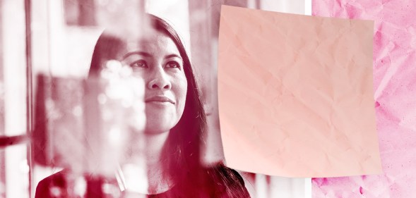 Woman looking at sticky notes at work