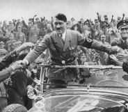 Adolf Hilter in an open-air car greeting Nazi supporters