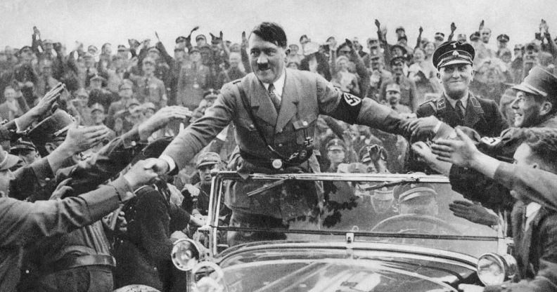 Adolf Hilter in an open-air car greeting Nazi supporters