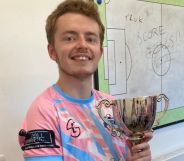 Arthur Webber holds up a trophy as he wears the TRUK United FC football kit, and he is set to captain the club's first all-trans men team