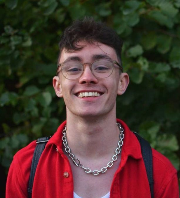 Dean O'Reilly pictured outdoors wearing glasses and a red shirt with a chain around his neck.