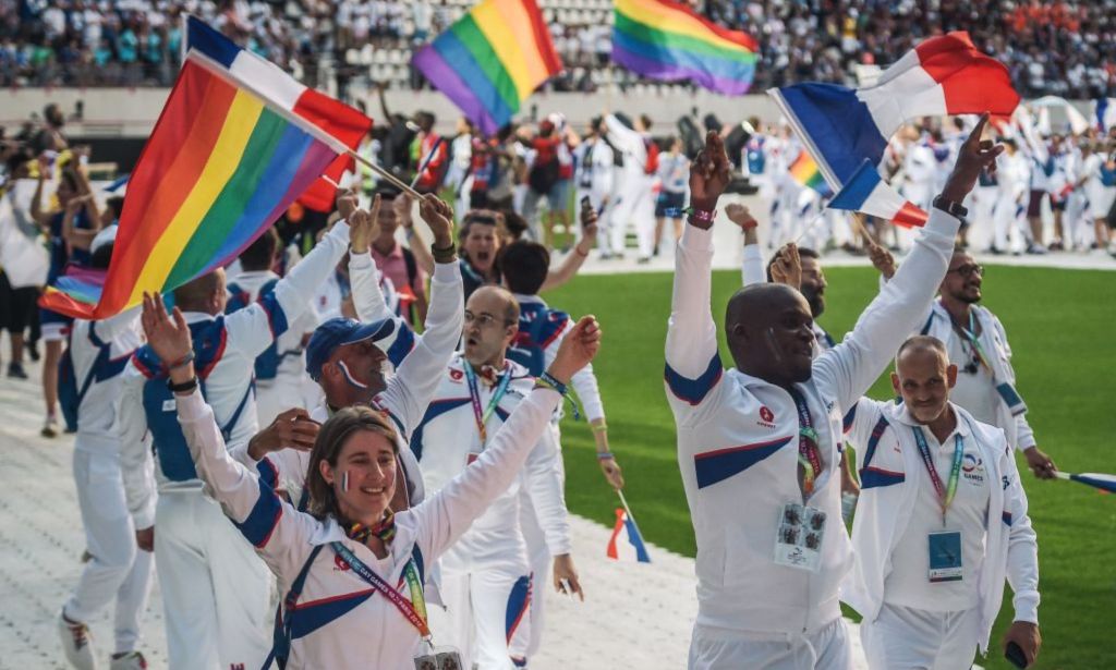 LGBTQ+ athletes holding Pride flags at the 2018 Gay Games.