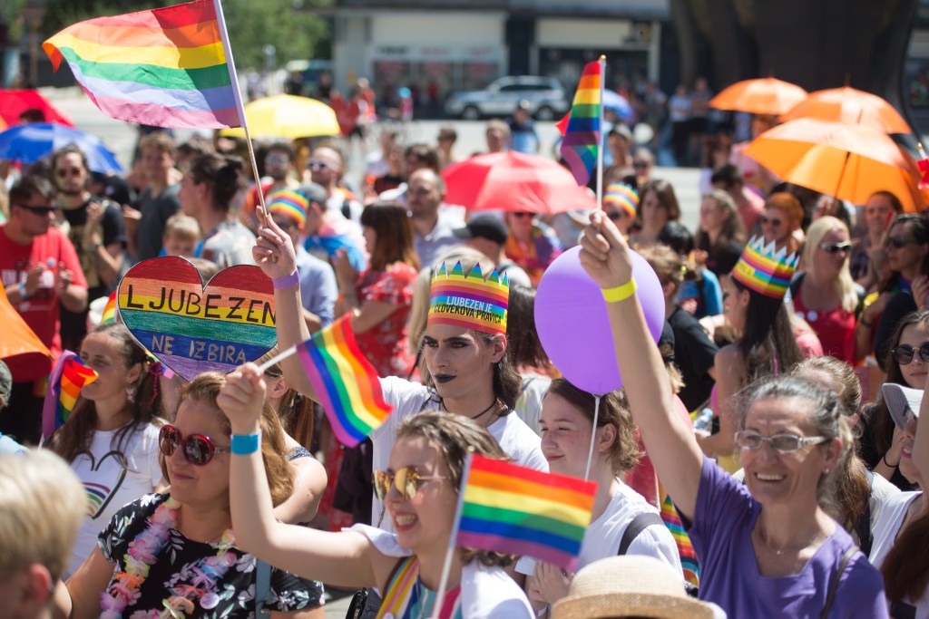 People hold rainbow flags at a pride parade