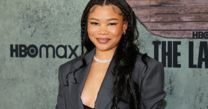 Storm Reid pictured wearing a suit top with a black bra underneath, in front of a grey background at the Los Angeles Premiere of The Last of Us