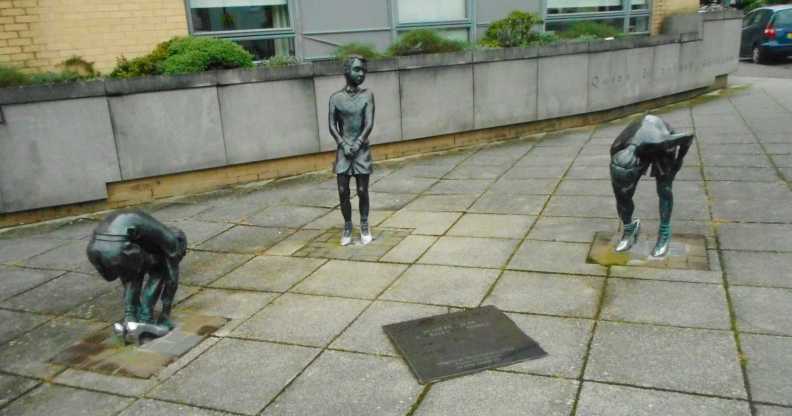 A photo shows the Gorbals Boys artwork piece in Glasgow. There are three statues showing three boys in different positions wearing women's shoes