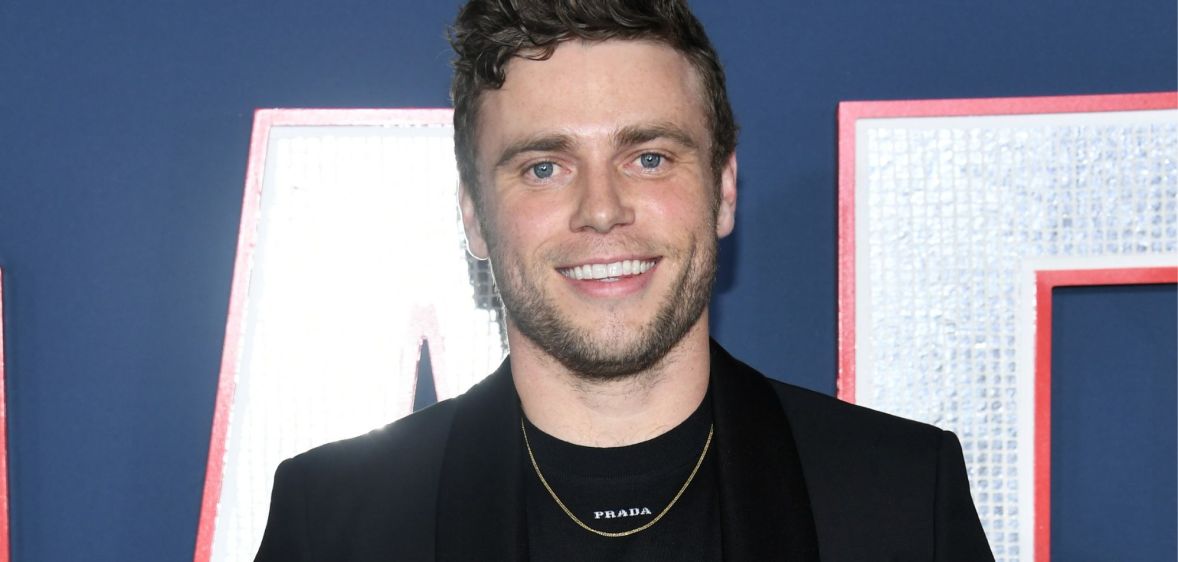 Photo of actor Gus Kenworthy wearing a black suit at the 80 for brady premiere