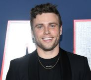 Photo of actor Gus Kenworthy wearing a black suit at the 80 for brady premiere
