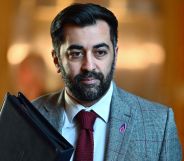 Humza Yousaf walking down a hall.