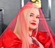 Kim Petras wears a sheer red veil on the red carpet at the 2023 Grammy awards.