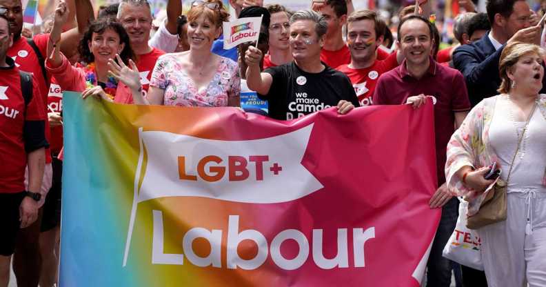 A photo showing LGBT+ Labour at Pride marching amongst a large crowd as they hold a banner that says "LGBT+ Labour"