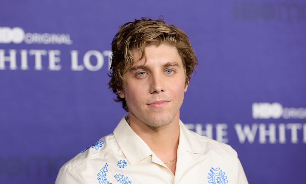 Lukas Gage at the premiere for the White Lotus season 2 wearing a white and blue shirt