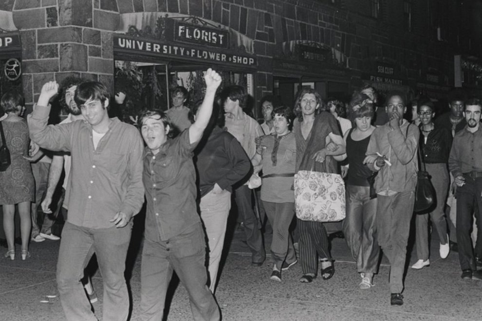 Stonewall Riots veteran Mark Segal (front-right) raising a fist during a march