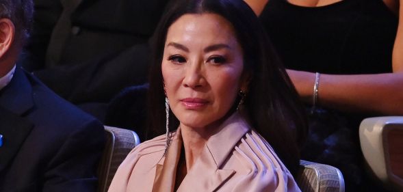 Michelle Yeoh looks down while seated at the 2023 BAFTA Awards ceremony.