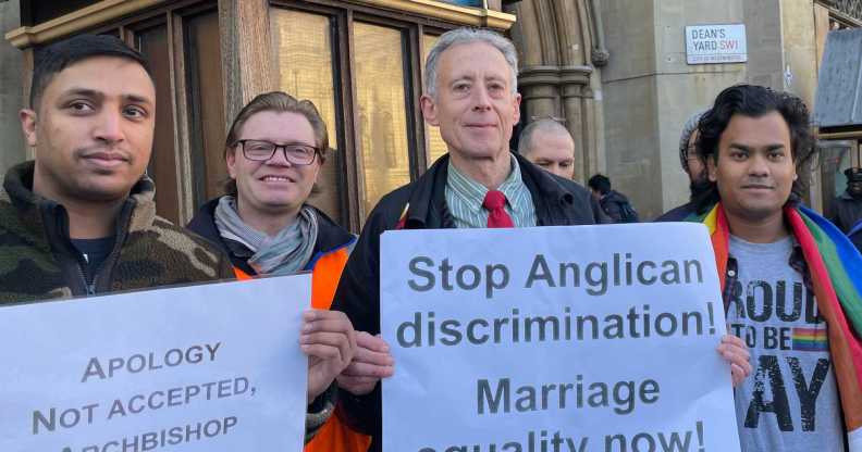 Photo of protestors standing outside the Church of England's General Synod holding signs. One of them reads "Stop Anglican discrimination. Marriage equality now".
