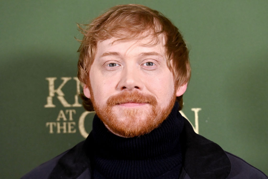 Rupert Grint in a black turtleneck against a green backdrop for Knock at the Cabin