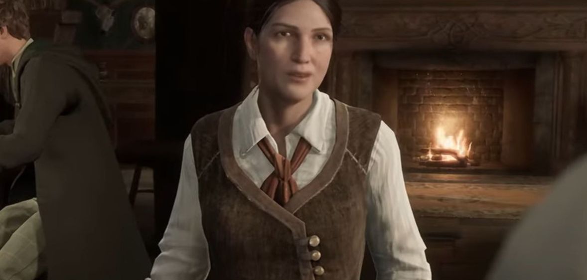 A screenshot from Hogwarts Legacy video game showing trans character Sirona Ryan wearing a white shirt and brown waistcoat