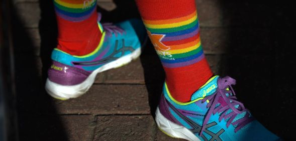 A person wearing LGBT socks and trainers.