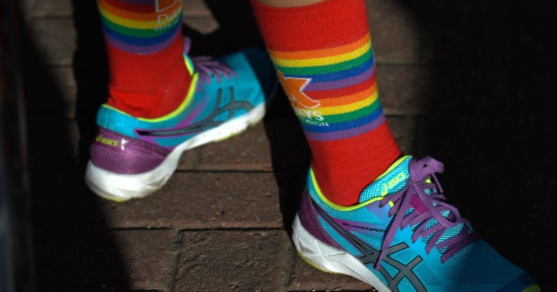 A person wearing LGBT socks and trainers.