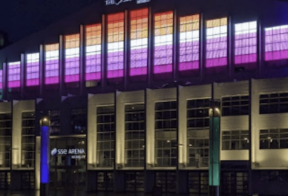 The OVO Arena Wembley in London lit up in lesbian Pride flag colours