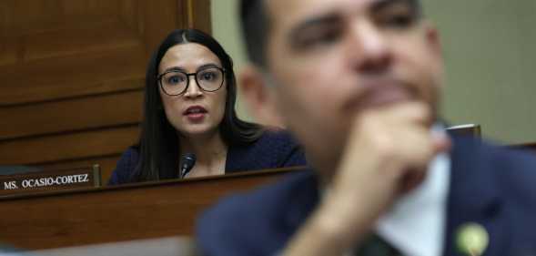 Alexandria Ocasio-Cortez (D-NY) (L) listens during a hearing before the House Oversight and Accountability Committee at Rayburn House Office Building on Capitol Hill (Alex Wong/Getty Images)
