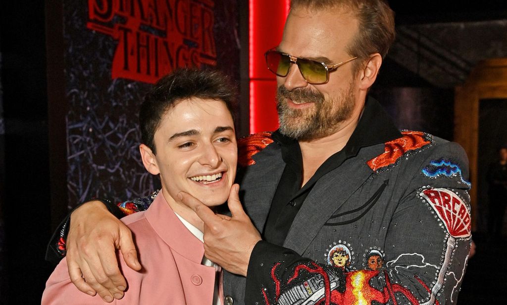 Stranger Things actor David Harbour hugs and affectionately holds the face of his co-star Noah Schnapp