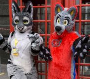 Two people, who are part of the furry community, dress in colourful fursuits as they pose outside in London for a photograph