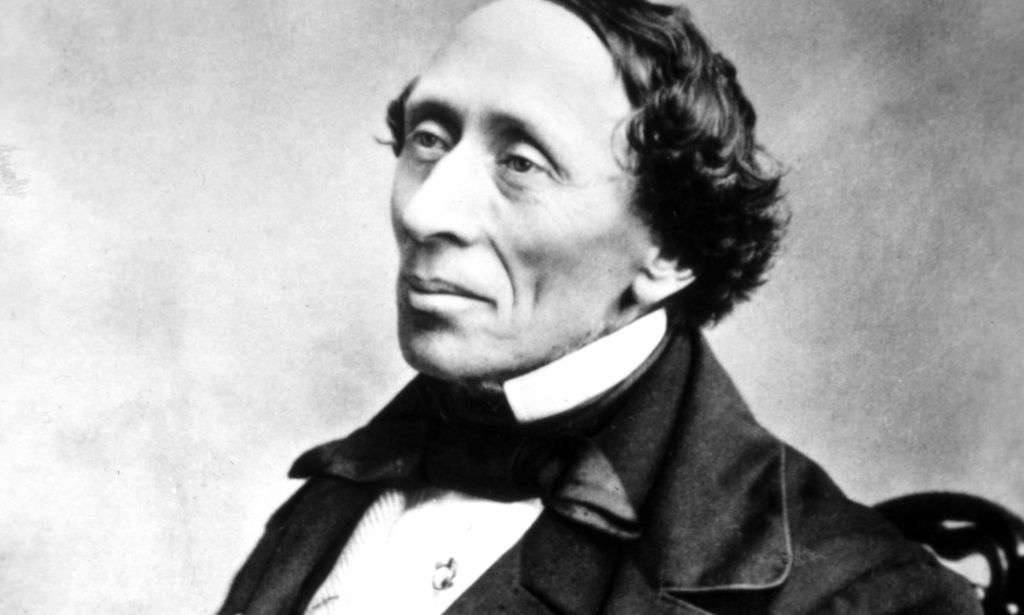 A black and white photograph of Danish author Hans Christian Andersen wearing a white shirt and dark clothing as he poses for the camera