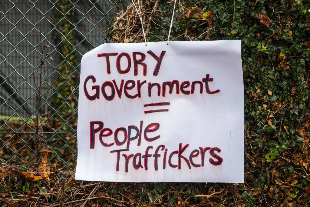 A sign reading "Tory Government = People traffickers" is pictured during a protest outside Manston asylum centre. 
