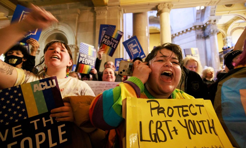 A crowd of people hold up signs in support of the LGBTQ+ community as they gather to protest Indiana state legislature considering a 'Don't Say Gay or Trans' bill