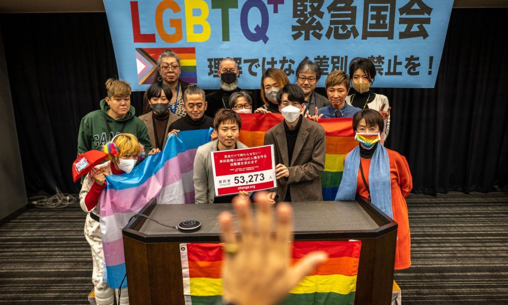 LGBTQ+ and human rights campaigners gather together and hold up a trans Pride flag and rainbow LGBTQ+ flag as they call on Japan's government to introduce anti-discrimination protections for LGBTQ+ people in the country