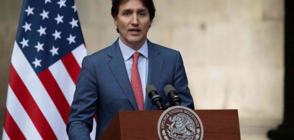 Justin Trudeau in front of a US flag