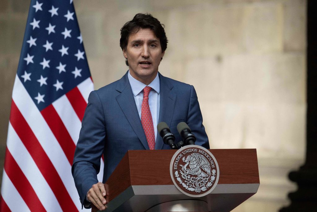 Justin Trudeau in front of a US flag