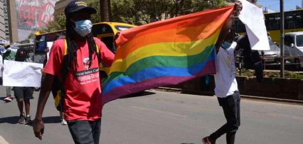 Demonstrators are seen marching with an LGBTQ+ flag during a protest in Nairobi.