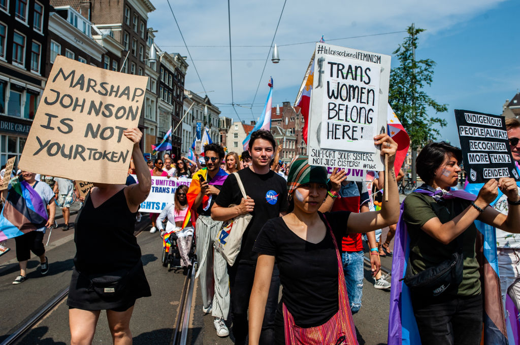 A person holds a sign about Marsha P Johnson at a Pride march in Amsterdam. 