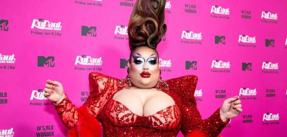 A photo of drag queen Mistress Isabelle Brooks from RuPaul's Drag Race season 15 wearing an over-the-top red dress as she poses for the cameras at an MTV publicity event