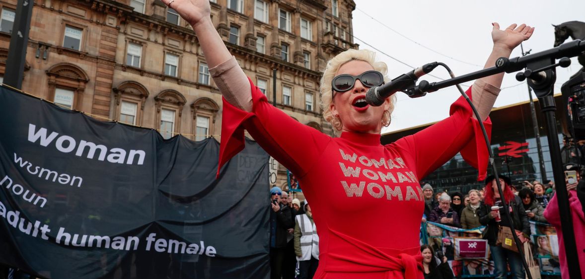 Anti-trans activist Kellie-Jay Keen, also known as Posie Parker, wears a red outfit as she speaks at an event which was met with counter-protesters