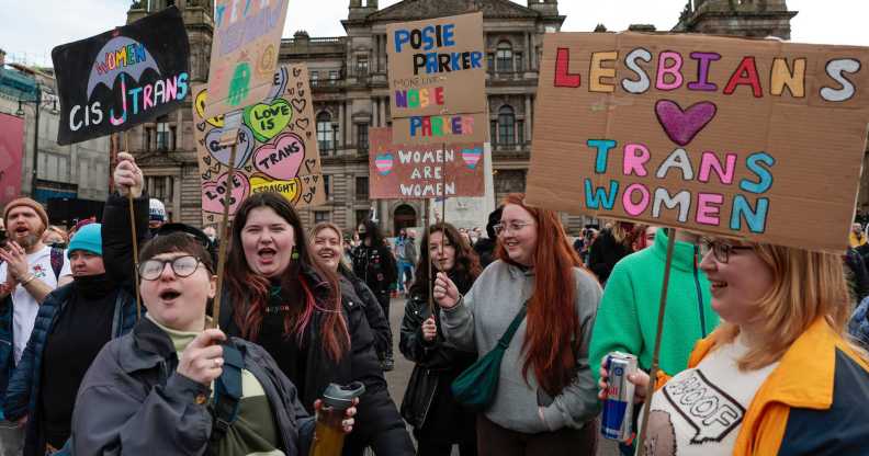 A photo showing trans rights protesters in Glasgow holding placards with messages saying "Lesbians love trans women"
