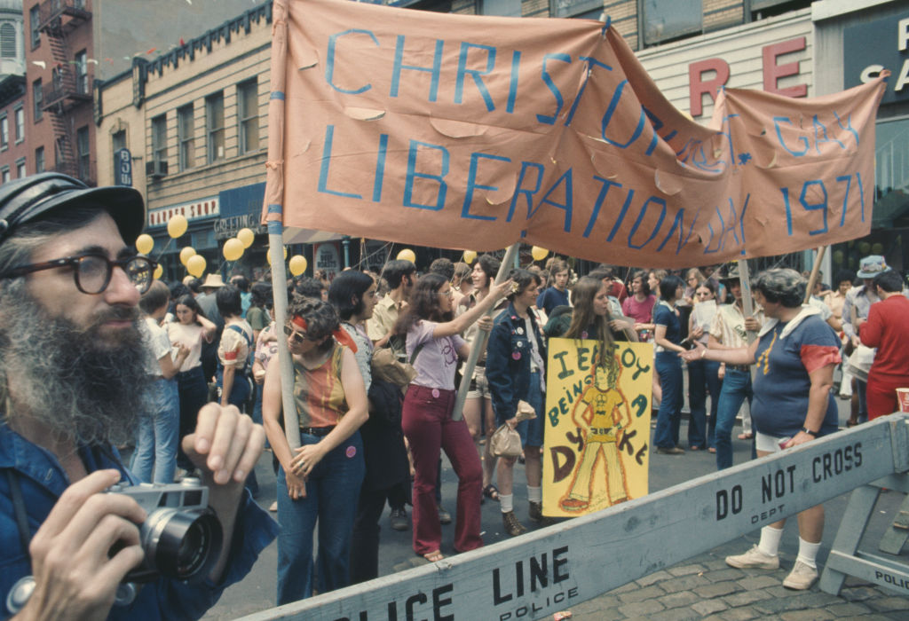 An LGBT parade through New York City on Christopher Street Gay Liberation Day reaches a police line, 1971.