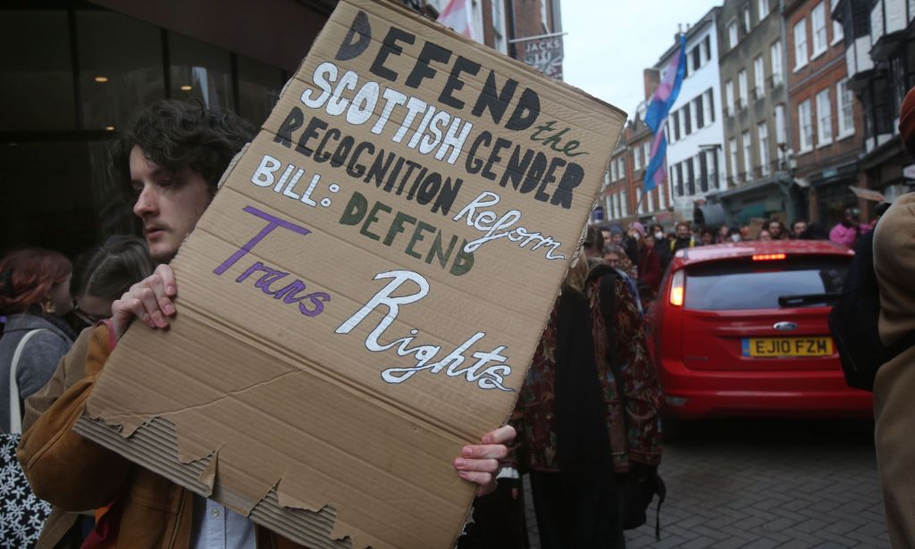 A member of the march holds up a sign saying Defend the Scottish Gender. Recognition Reform Bill, Defend Trans Rights during a protest