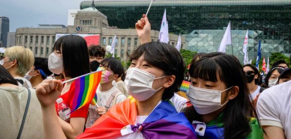 A crowd of people waving Pride flags