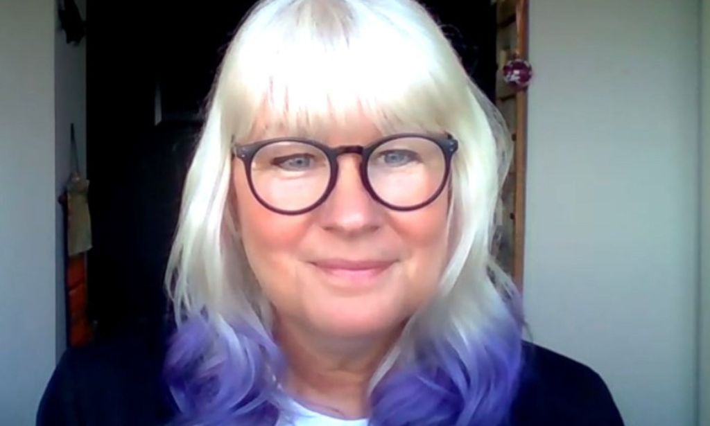 Suse Green, a trans advocate, stares towards the camera with blonde hair that has purple ends